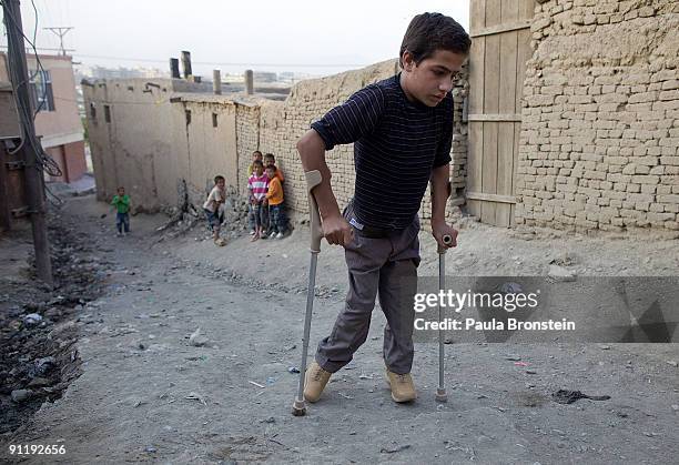 Fawad Rahmani makes his way home using his crutches and special braces fitted from the ICRC Orthopedic clinic on September 26, 2009 in Kabul,...