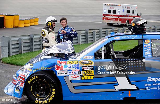 Martin Truex Jr., driver of the Vaseline MEN Body Lotion Chevrolet talks with an official after being involved in a crash during the NASCAR Sprint...