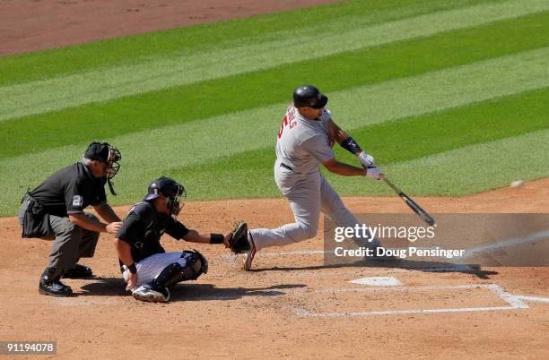 Albert Pujols of the St. Louis Cardinals hits a three RBI double with catcher Yorvit Torrealba of the Colorado Rockies and homeplate umpire Larry...