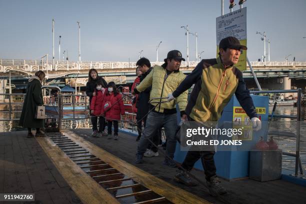 This photo taken on January 15, 2018 shows passengers onboard a 'gaetbae' hand-pulled boat connecting the "Abai village", a village made up of North...