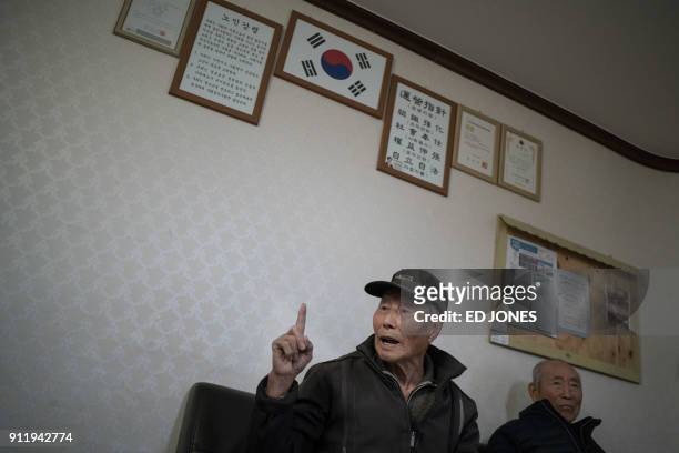 In a photo taken on January 15 North Korean refugee Kim Kun-Wook gestures beneath a South Korean flag as he sits in a meeting area in "Abai village",...