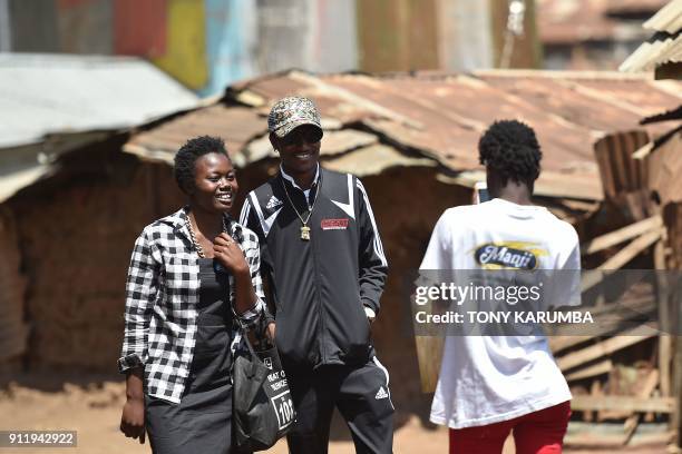 Kenyan hip hop artist Henry Ohanga , who hails from Kenya's largest slum Kibera in Nairobi, poses with a fan during a visit to Kibera on January 16,...