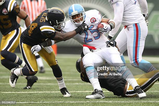 LenDale White of The Tennessee Titans is tackled by Darrelle Revis and Bart Scott of The New York Jets during their game on September 27, 2009 at...