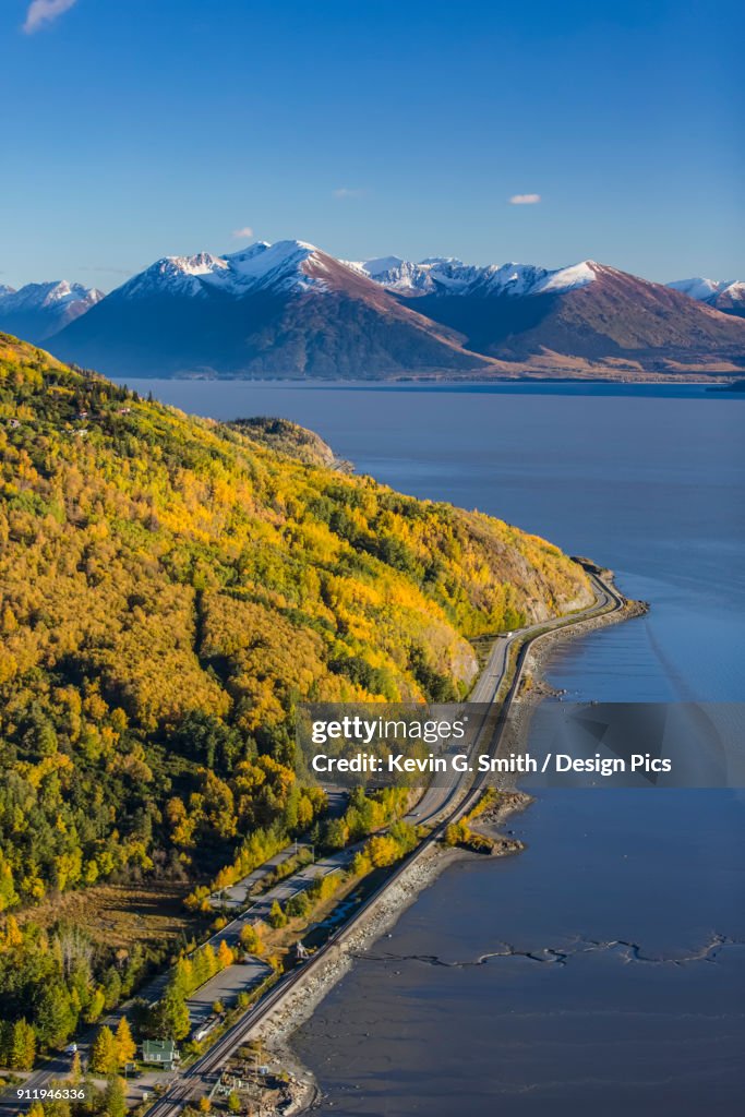 Aerial View Of The Seward Highway Running South Along The Turnagain Arm, Snow Covering The Kenai Mountains In The Background, Autumn Coloured Trees Filling The Hillsides, South-Central Alaska