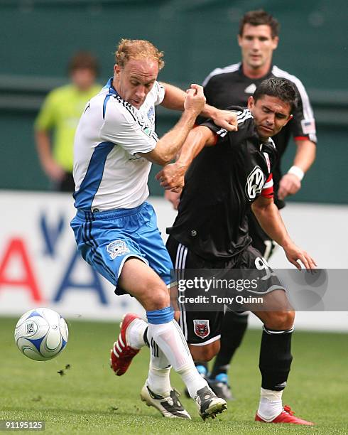 Jaime Moreno of D.C. United struggles for the ball with Simon Elliott of San Jose Earthquakes during an MLS match at RFK Stadium on September 27,...