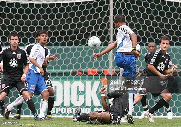 Julius James of D.C. United slides in to stop a shot from Ryan Johnson of San Jose Earthquakes during an MLS match at RFK Stadium on September 27,...