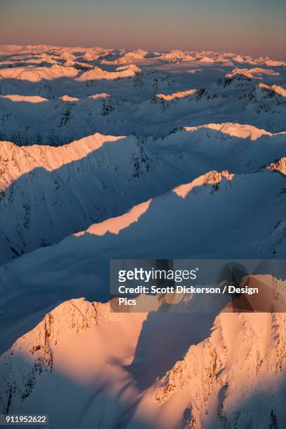 peaks of a snow covered mountain range glowing pink at sunset, kachemak bay state park - sunset bay state park stockfoto's en -beelden