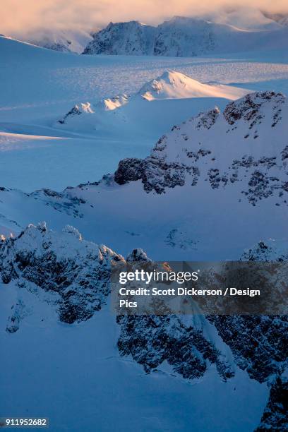 peaks of a snow covered mountain range glowing at sunset, kachemak bay state park - sunset bay state park stockfoto's en -beelden