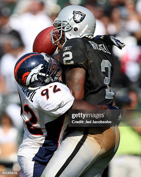 JaMarcus Russell of the Oakland Raiders is sacked by Elvis Dumervil of the Denver Broncos on September 27, 2009 during an NFL game at the...