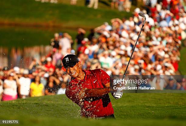Tiger Woods plays a bunker shot on the 18th hole during the final round of THE TOUR Championship presented by Coca-Cola, the final event of the PGA...