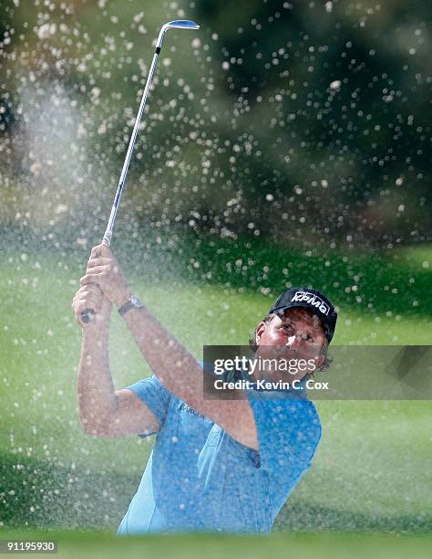 Phil Mickelson hits out of a sand trap onto the 10th green during the final round of THE TOUR Championship presented by Coca-Cola, the final event of...