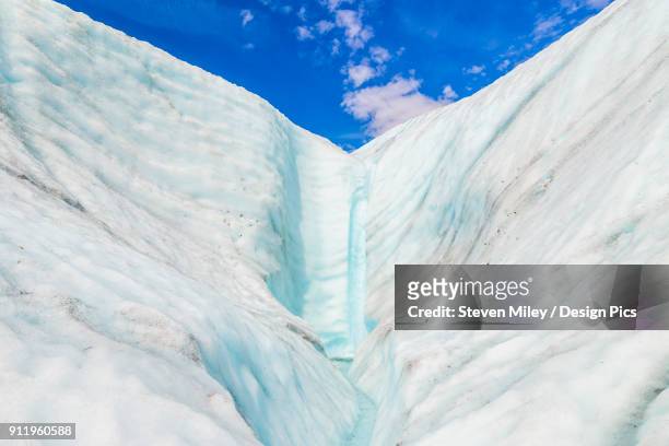 a waterfall pours down the ice of root glacier in wrangell-st. elias national park - root glacier stock-fotos und bilder