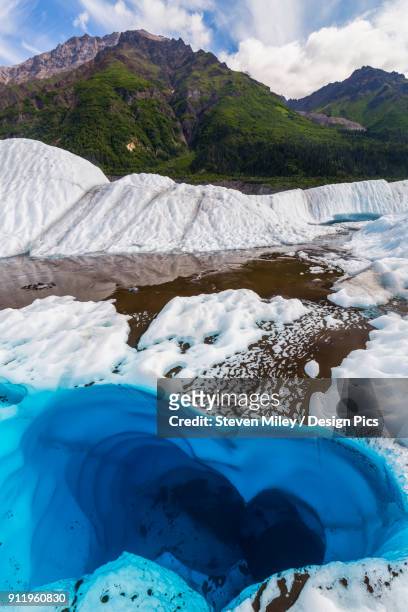 a pool of water on the surface of root glacier in wrangell-st. elias national park resembles a heart shape - root glacier stockfoto's en -beelden