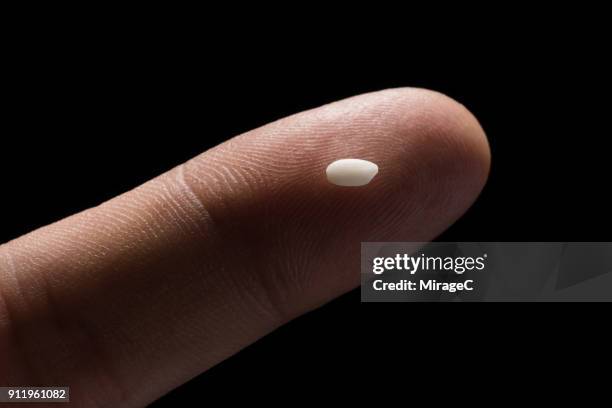 a grain of rice on tip of finger - rijst stockfoto's en -beelden