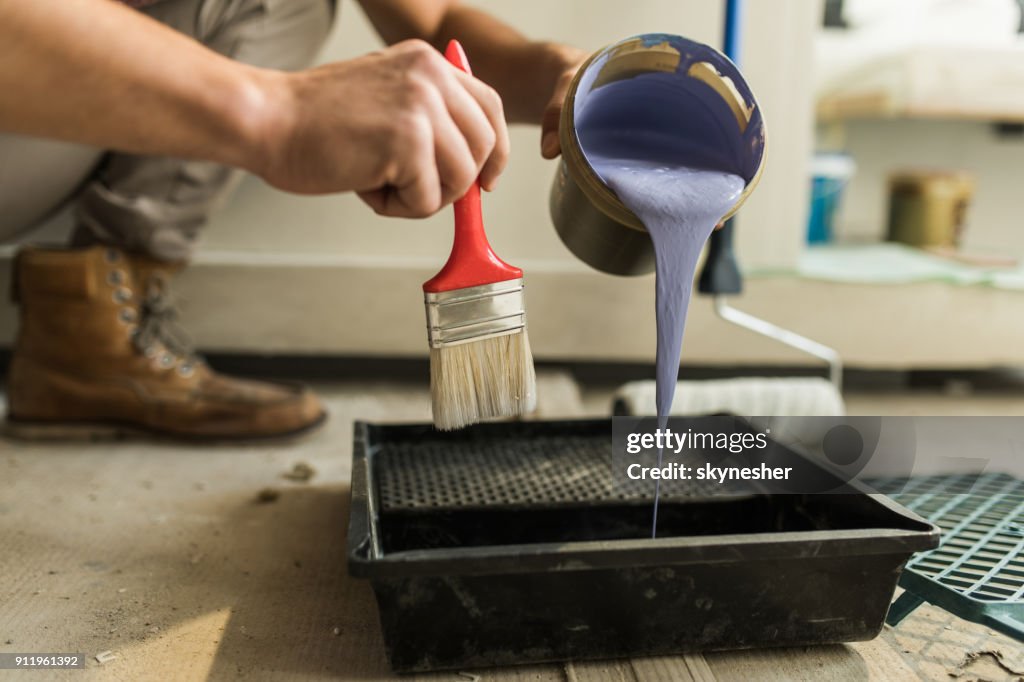 Cerca de persona irreconocible preparación de pintura para la decoración casera.