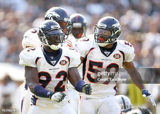 Wesley Woodyard congratulates Elvis Dumervil of the Denver Broncos after Dumervil sacked JaMarcus Russell of the Oakland Raiders at the...
