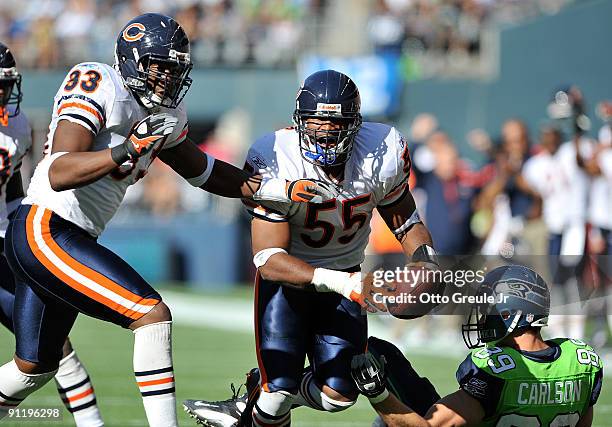 Linebacker Lance Briggs of the Chicago Bears and defensive end Adewale Ogunleye celebrate after Briggs made an interception against John Carlson of...
