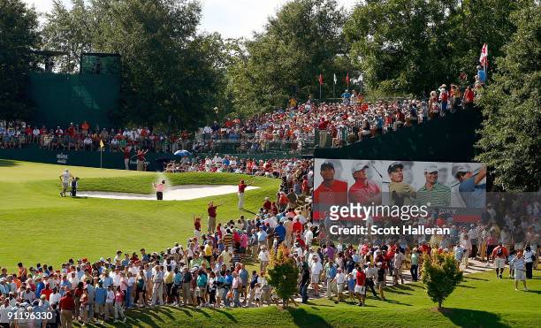 Golf fans watch the play at the 18th green during the final round of THE TOUR Championship presented by Coca-Cola, the final event of the PGA TOUR...