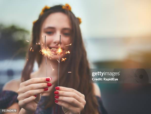 two lit sparklers held by beautiful young woman twinkle brightly - flower crown stock pictures, royalty-free photos & images