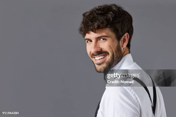 glücklich geschäftsmann vor grauem hintergrund - mann portrait seitlich stock-fotos und bilder