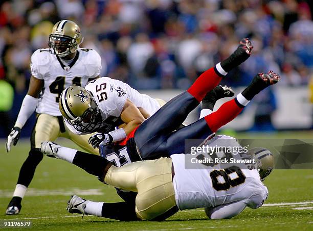 Josh Reed of the Buffalo Bills is tackled by Scott Fujita and Sedrick Ellis of the New Orleans Saints at Ralph Wilson Stadium on September 27, 2009...