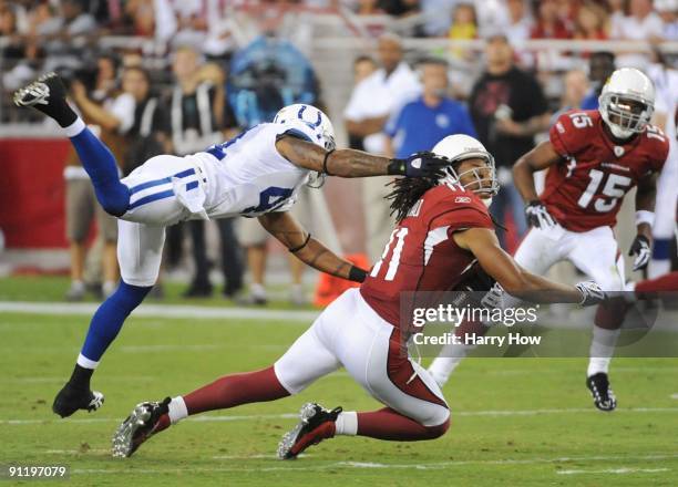 Larry Fitzgerald of the Arizona Cardinals makes a 16-yard catch as Antoine Bethea of the Indianapolis Colts grabs his facemask for a 15-yard penalty...