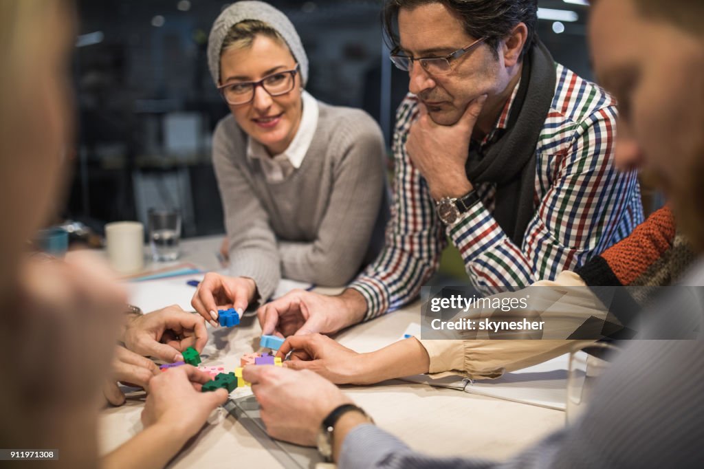 Grupo de pessoas criativas, conectando as peças do quebra-cabeça no escritório.