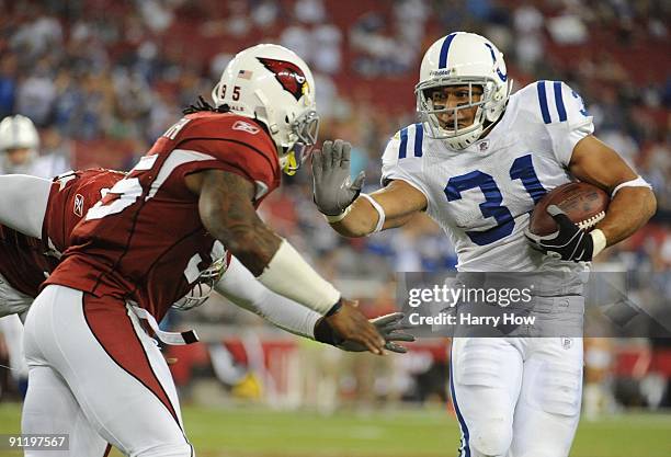 Donald Brown of the Indianapolis Colts stiff arms Ali Highsmith of the Arizona Cardinals in the fourth quarter during the game at University of...