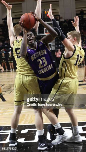 Mike Amius forward Western Carolina University is fouled as he shoots between two Wofford defenders. Western Carolina and Wofford College met for...
