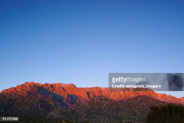 paisagem de montanha ao pôr do sol vermelho com céu azul - albuquerque novo méxico - fotografias e filmes do acervo