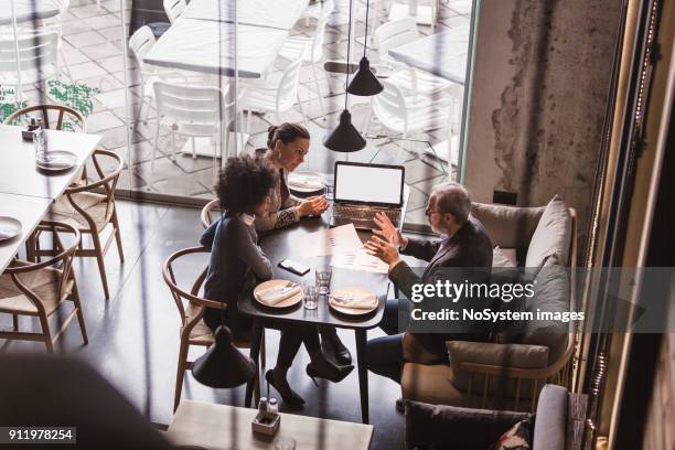 hommes d'affaires ayant réunion dans le restaurant. - liens affectifs photos et images de collection
