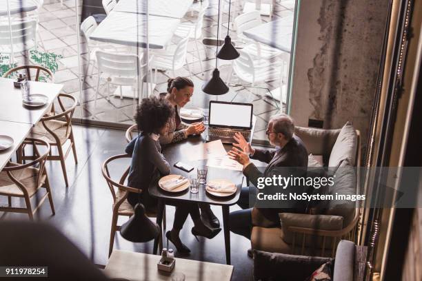 hommes d'affaires ayant réunion dans le restaurant. - rapport photos et images de collection