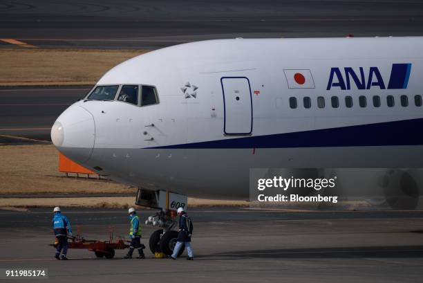 Ground crew members work near an All Nippon Airways Co. Aircraft at Narita Airport in Narita, Chiba Prefecture, Japan, on Sunday, Jan. 28, 2018. ANA...