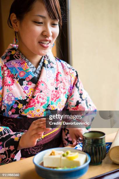 front view portrait of a beautiful woman with traditional dress having tea and cake  in kyoto, japan - tea dress stock pictures, royalty-free photos & images