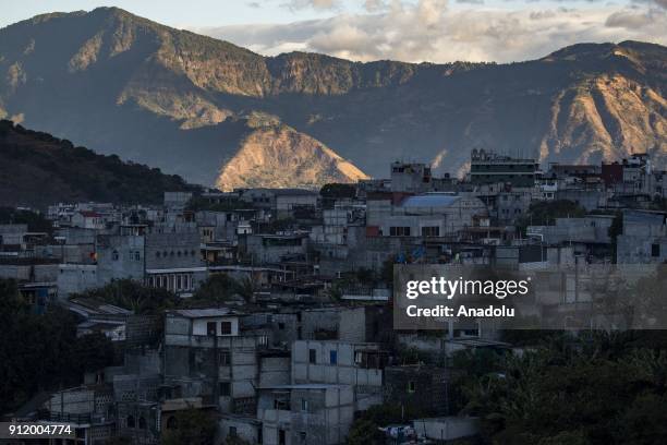 The rising sun illuminates the mountain ridge across the lake while Santiago Atitlan remains in the shadows in the early morning on Lake Atitlan,...