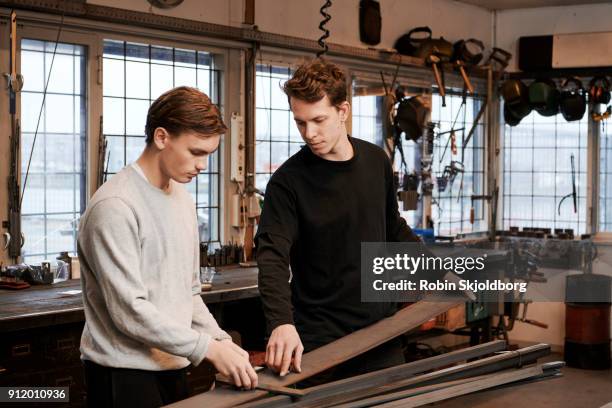 blacksmith teaching student in workshop - robin skjoldborg stock pictures, royalty-free photos & images
