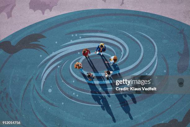 group of people standing in center of whirlpool, painted on asphalt and looking up - young artists unite fotografías e imágenes de stock