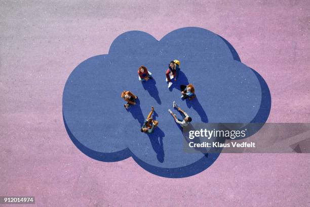 group of people sitting in circle on a cloud, painted on asphalt and looking up - estar-en-las-nubes fotografías e imágenes de stock