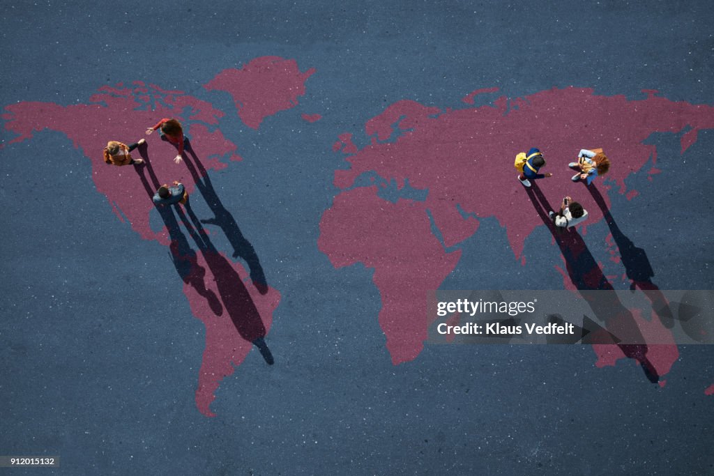 Two Small Groups Of People Having Discussion Standing On World Map ...