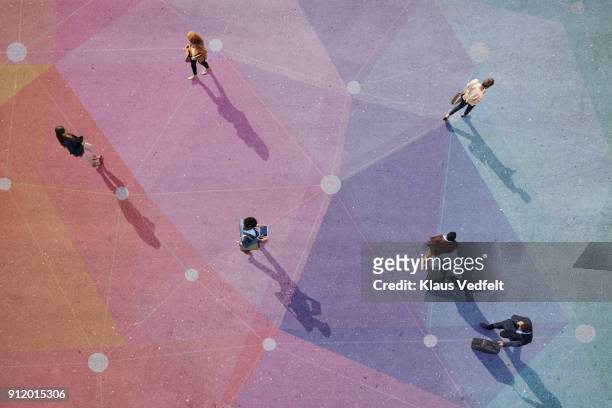 top view of people walking in different directions of pattern, painted on asphalt - zusammenhalt stock-fotos und bilder