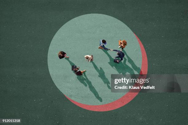 top view of businesspeople making handshake. standing in circle on painted asphalt - compatibilité photos et images de collection