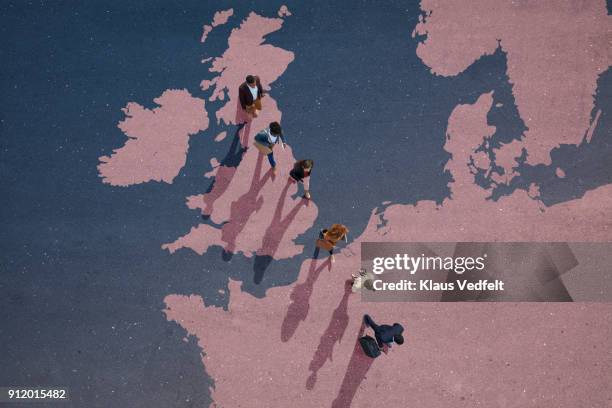 top view of businesspeople walking out of great britain on painted north european map - brexit people stock pictures, royalty-free photos & images