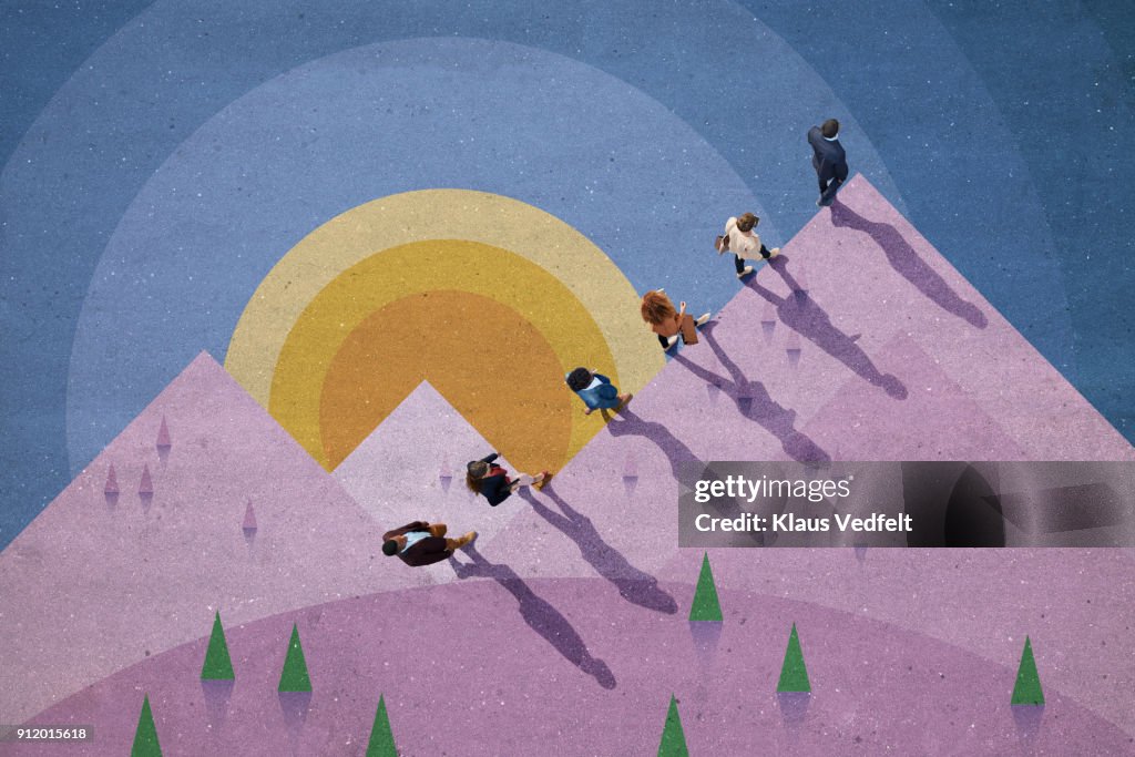 Businesspeople walking up mountain side, painted on asphalt
