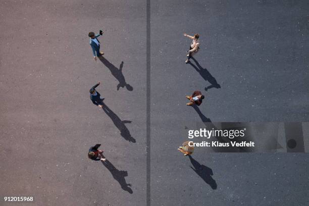 6 business people facing each other, with line dividing them, on painted asphalt - social distancing stockfoto's en -beelden