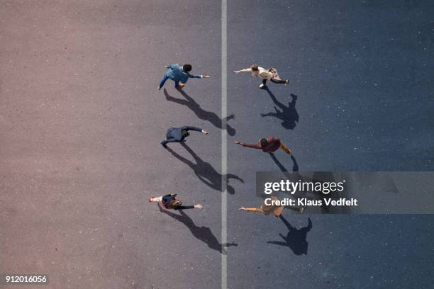 businesspeople stretching towards each other, on painted asphalt - crecimiento estirón fotografías e imágenes de stock