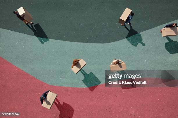 businesspeople carrying boxes around on painted lanes on asphalt - transition collage stockfoto's en -beelden