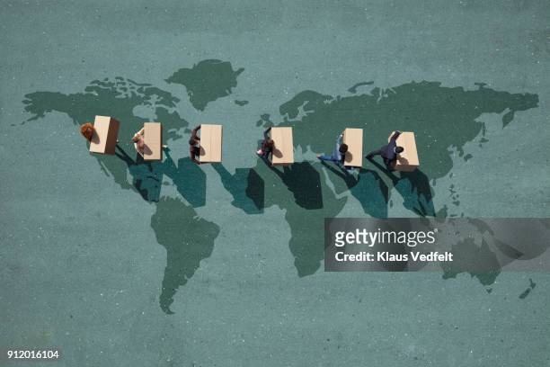 businesspeople walking across painted world map, carrying moving boxes - immigrants stockfoto's en -beelden