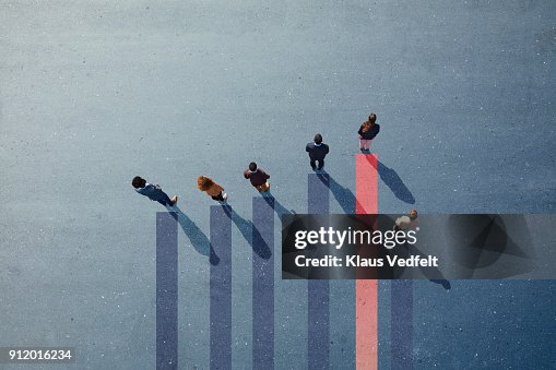 Businesspeople standing on painted bar chart graph on asphalt Businesspeople standing on painted bar chart graph on asphalt