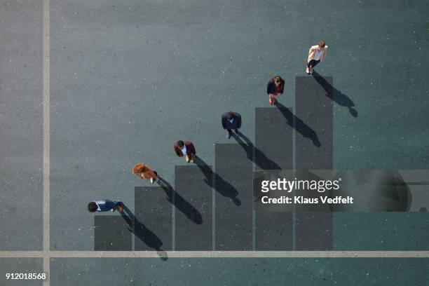 businesspeople standing on painted bar chart on asphalt - measure foto e immagini stock