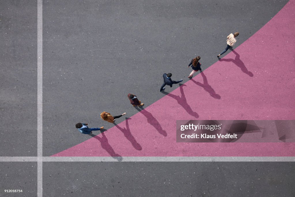 Businesspeople walking on painted up going graph, on asphalt